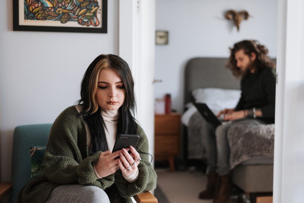 Ein Paar sitzt getrennt und nachdenklich – ein Moment der Distanz und Reflexion. Das Bild symbolisiert Konflikte und die Herausforderung, Beziehungsprobleme offen anzusprechen und gemeinsam Lösungen zu finden